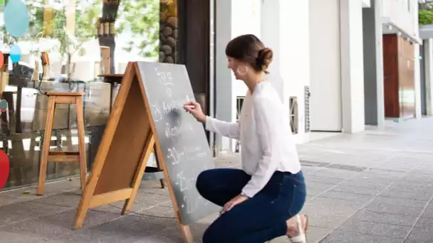 Business owner writing on foot traffic sign