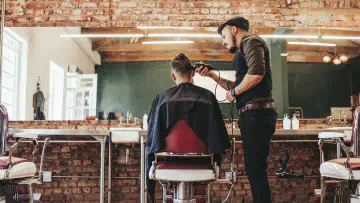 Professional barber cutting client&#x27;s hair