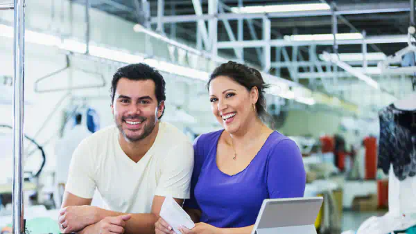 Two laundromat owners stand at front desk