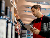 Liquor store owner checking wine bottle